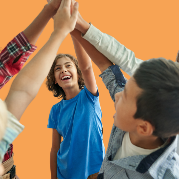 Gruppe aus Kindern machen im Klassenzimmer zusammen ein High Five 