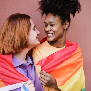 Paar in Regenbogenflagge gewickelt
