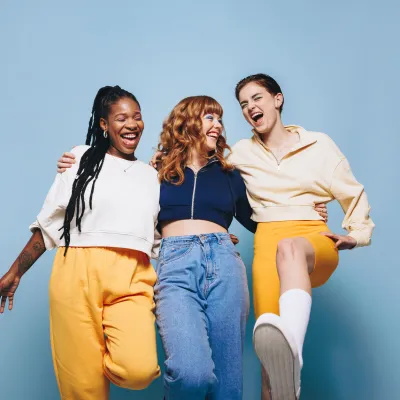 Gruppe aus 3 Personen lachen gemeinsam Gruppe aus 3 Personen lachen gemeinsam Arm in Arm